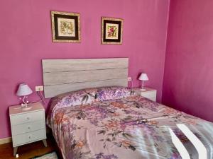 a pink bedroom with a bed and two night stands at ALOJAMIENTO ENTERO CON PISCINA Y JARDIN. in Ourense +61 photos