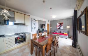 uma cozinha e sala de jantar com mesa e cadeiras em Stunning Home In Kastel Gomilica With 2 Bedrooms And Wifi em Kaštela