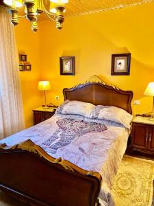 a bedroom with a large bed with yellow walls at ALOJAMIENTO ENTERO CON PISCINA Y JARDIN. in Ourense