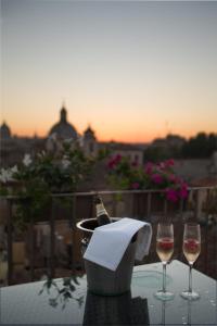 2 verres à vin assis sur une table avec une bouteille de vin dans l'établissement Relais Arco Della Pace, à Rome