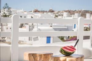 a watermelon cut in half sitting on two stools at Kostantis Town Suites in Mikonos