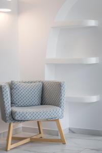 a chair in a room with a white wall at Kostantis Town Suites in Mikonos