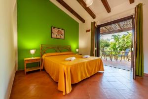 a bedroom with a green wall and a bed and a table at Happy Village in Marina di Camerota