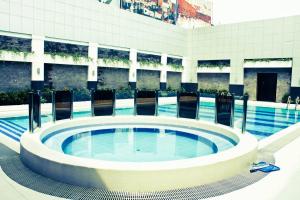 a large swimming pool with a large tub in a building at Manila Grand Opera Hotel in Manila