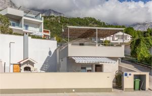 a white house with a mountain in the background at 3 Bedroom Lovely Home In Makarska in Makarska +20 photos