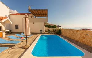 a swimming pool with lounge chairs and an umbrella at 3 Bedroom Lovely Home In Makarska in Makarska