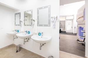 a bathroom with two sinks and mirrors on the wall at Space Home Apartment - City Hall in Vienna