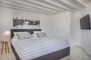 a bedroom with a bed and a tv on a wall at Kostantis Town Suites in Mýkonos City