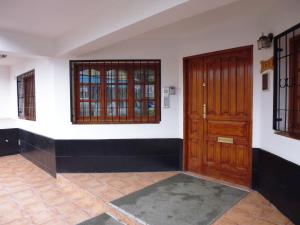 um quarto vazio com uma porta de madeira e janelas em Apart Hotel Cabo San Diego em Ushuaia