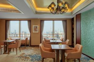 a restaurant with tables and chairs and windows at Radisson Blu Hotel Shanghai New World in Shanghai