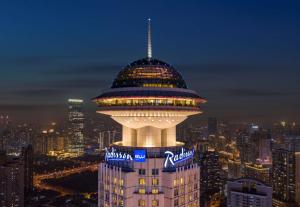 a night view of the control tower of a building at Radisson Blu Hotel Shanghai New World in Shanghai