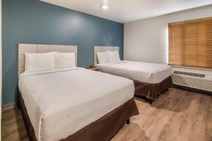 WoodSpring Suites Denton tesisinde bir odada yatak veya yataklar