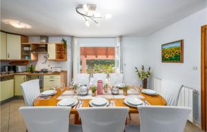 马尔卡纳Amazing Home In Marcana的一间带桌子和白色椅子的餐厅