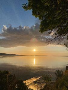 a boat on a lake with the sun setting at Villa Franko in Prizna