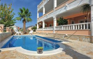 a swimming pool in front of a house at Nice Home In Kastel Stari With 6 Bedrooms, Wifi And Outdoor Swimming Pool in Kaštela