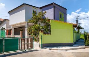 une maison colorée avec un portail en face de celle-ci dans l'établissement Amazing Home In Zminj With Kitchen, à Žminj