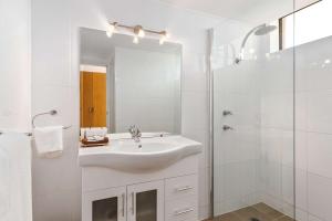 a white sink sitting under a mirror in a bathroom at Quality Inn Dubbo International in Dubbo