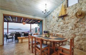 a dining room with a stone wall and a table and chairs at Stunning Home In Sevid With Kitchen in Sevid