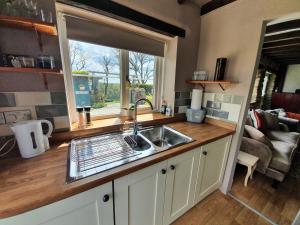 une cuisine avec un évier et une fenêtre dans l'établissement Stable End Cottage, à Narberth