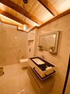ein Bad mit einem Waschbecken und einem Spiegel in der Unterkunft شاليهات رانس الريفية in Dschidda