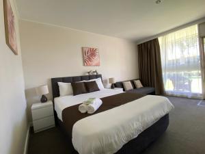 a hotel room with a large bed and a large window at Warrina Motor Inn in Wodonga