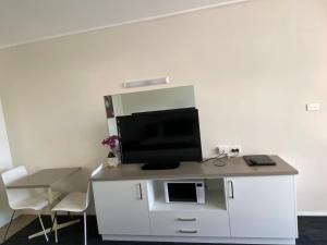 a kitchen with a stove and a microwave at Warrina Motor Inn in Wodonga