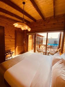 ein Schlafzimmer mit einem großen weißen Bett in einem Holzzimmer in der Unterkunft شاليهات رانس الريفية in Dschidda