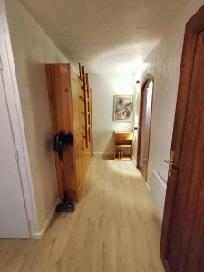 a hallway with a room with a door and a wooden floor at Appartement meublé avec vue sur les montagnes et piscine l'été in Saint-Gervais-les-Bains