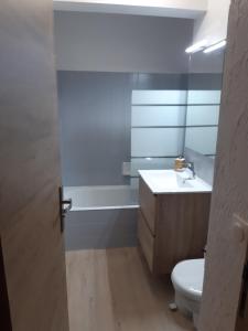 a bathroom with a white toilet and a sink at Appartement meublé avec vue sur les montagnes et piscine l'été in Saint-Gervais-les-Bains