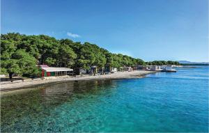 a body of water with a shoreline with trees at Two-Bedroom Apartment In Jadrija in Jadrija
