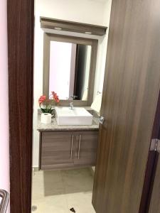 a bathroom with a sink and a mirror at Confortable, moderno y hermoso departamento. in Quito