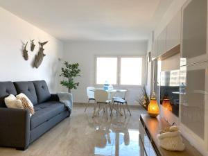 een woonkamer met een blauwe bank en een tafel bij PANORAMA MAR - Primera Linea - Lujo in Torrevieja