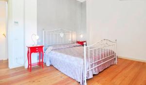 a bedroom with a white bed and a red night stand at Agriturismo Colombera in Quarto dʼAltino