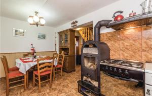 a kitchen with a stove and a dining room with a table at 2 Bedroom Beautiful Home In Plaski in Plaški