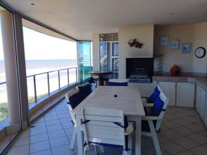 una sala da pranzo con tavolo, sedie e vista sull'oceano di Luxury 4 bedroom apartment a Margate