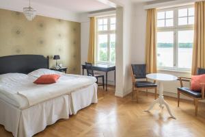Diö的住宿－Möckelsnäs Herrgård，卧室配有一张床和一张桌子及椅子