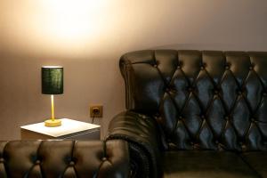 a living room with a leather couch and a lamp at HIDDEN BANK: Cash in Plovdiv