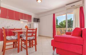 eine Küche und ein Wohnzimmer mit einem Tisch und einem roten Sofa in der Unterkunft Gorgeous Apartment In Baska Voda With Kitchen in Baška Voda