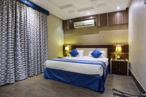 سرير أو أسرّة في غرفة في TIME Al Muruj Hotel Apartments