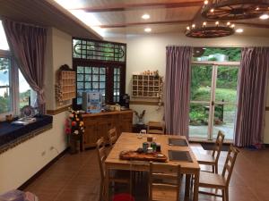 a dining room with a table and chairs and windows at 樂野仙蹤 in Alishan