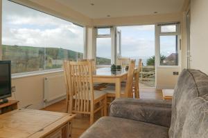 a living room with a table and chairs and a television at Hazelmere House in Woolacombe