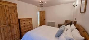 sypialnia z białym łóżkiem i drewnianą komodą w obiekcie Coal Office Aberlour w mieście Aberlour