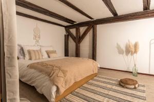 セレスタにあるL'Escale Bohème - Centre historique de Sélestatの大きなベッドとラグのある寝室 +11枚の写真