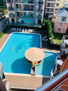 - une piscine avec une table et un parasol dans l'établissement Neptun Palace Kvariati, à Kvariati