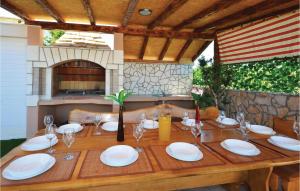 a wooden table with plates and wine glasses on it at 3 Bedroom Nice Home In Solin in Split