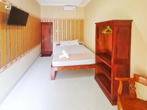a small bedroom with a bed and a cabinet at Graha Adi Karya Syariah Kartasura RedPartner in Kartosuro