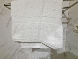- une pile de serviettes blanches sur un porte-serviettes dans la salle de bains dans l'établissement Graha Adi Karya Syariah Kartasura RedPartner, à Kartosuro