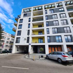 克卢日-纳波卡City Apartment Anton Pann的一栋白色建筑，前面停着一辆汽车