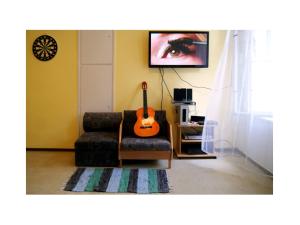 una sala de estar con una guitarra sentada en una silla en Westend Hostel, en Budapest