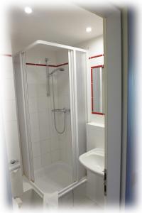 a white bathroom with a shower and a sink at Hotel Lindenberger Hof in Ahrensfelde